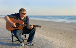 chanter et jouer de la guitare en même temps sur la plage